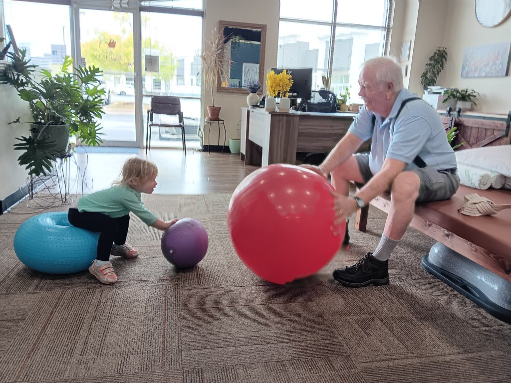 Patient performing exercises for low back pain relief with child.