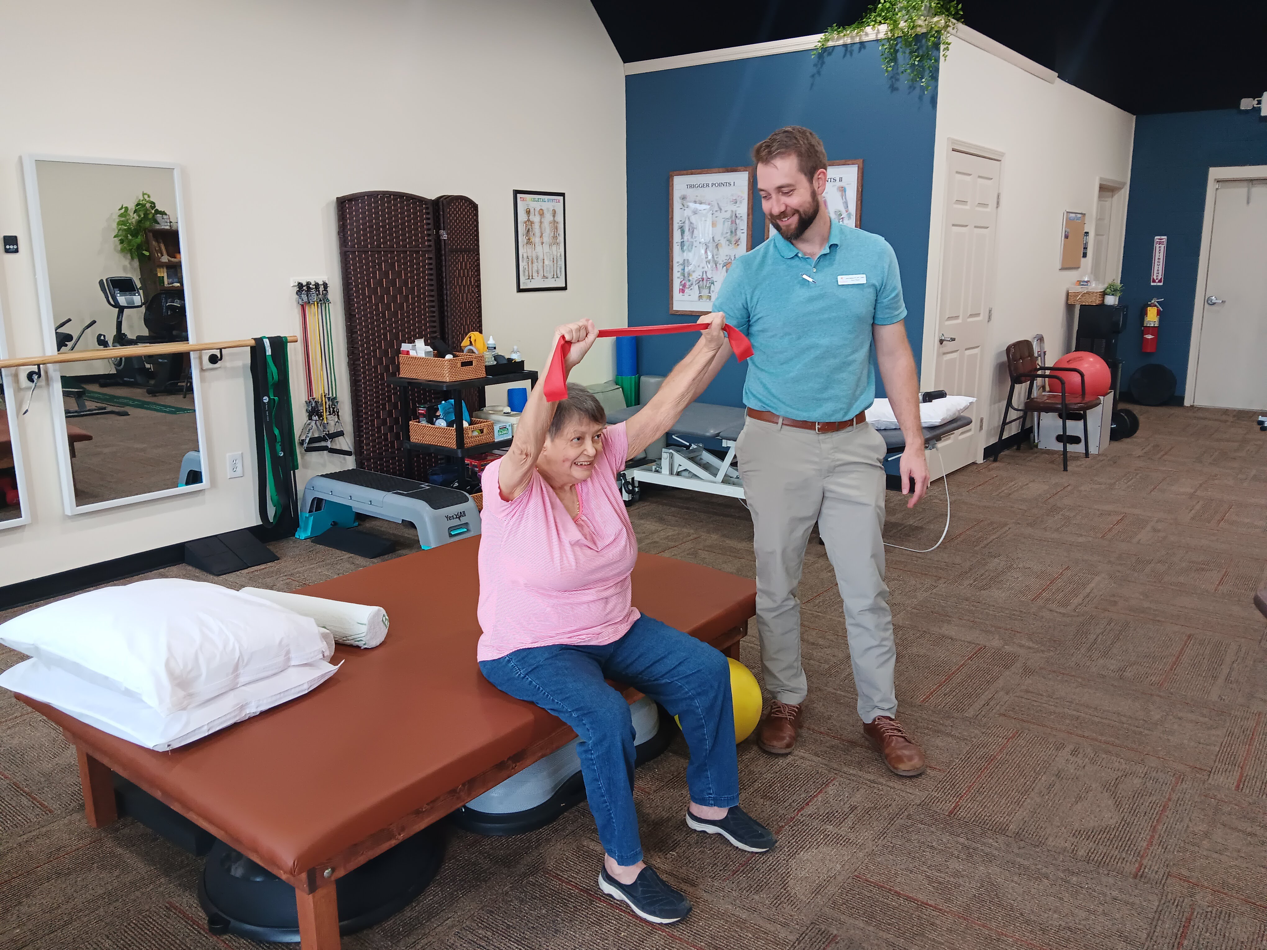 Jason Salisbury PT, DPT showing patient shoulder exercise to help neck and shoulder pain and be able to reach overhead.